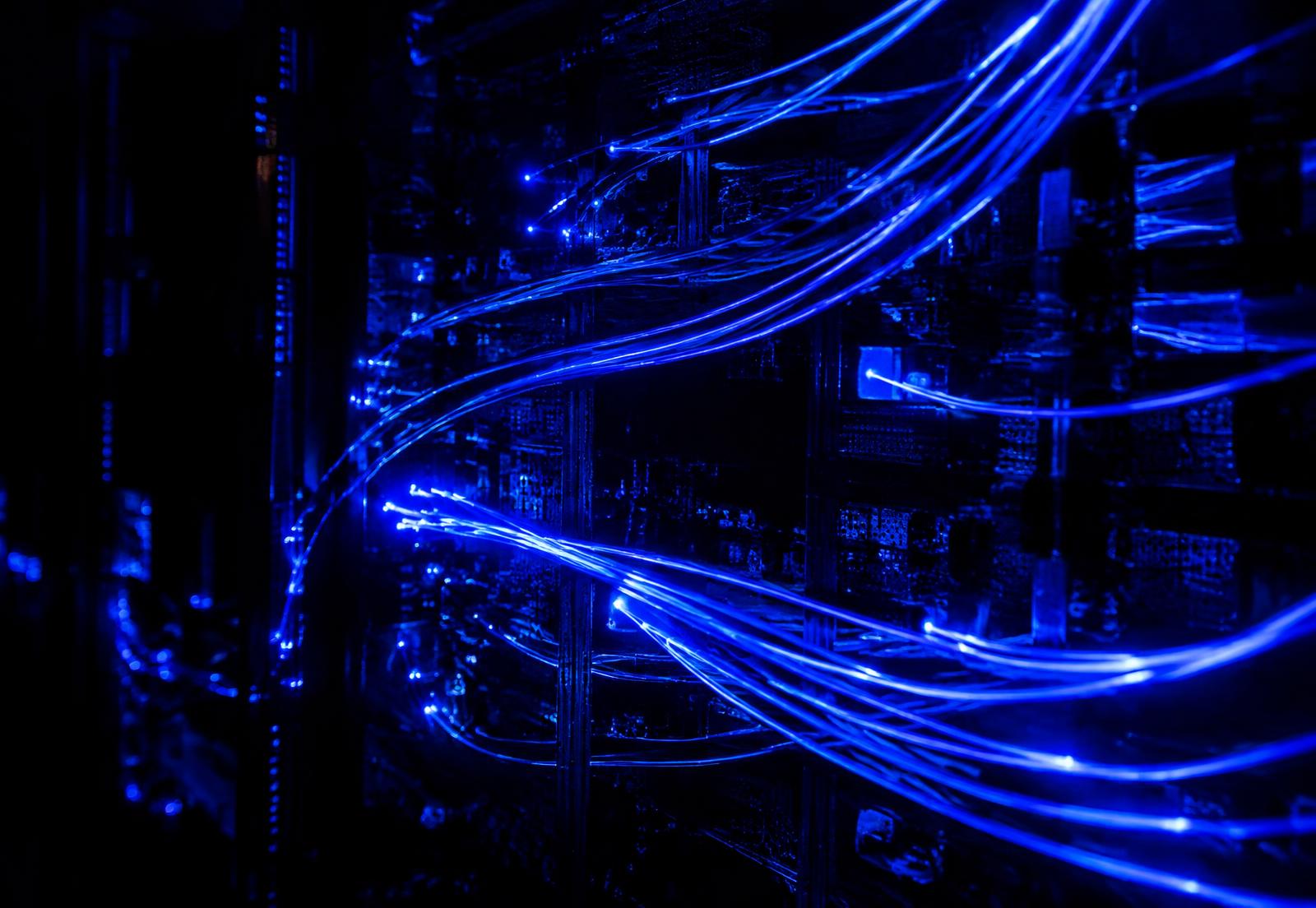 Cobalt fiber optic cables glowing across dark server hardware